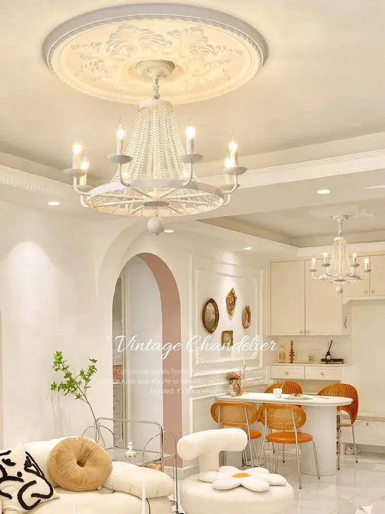A white ornate decorbites crystal chandelier with beaded crystal design and candle-style lights for dining room