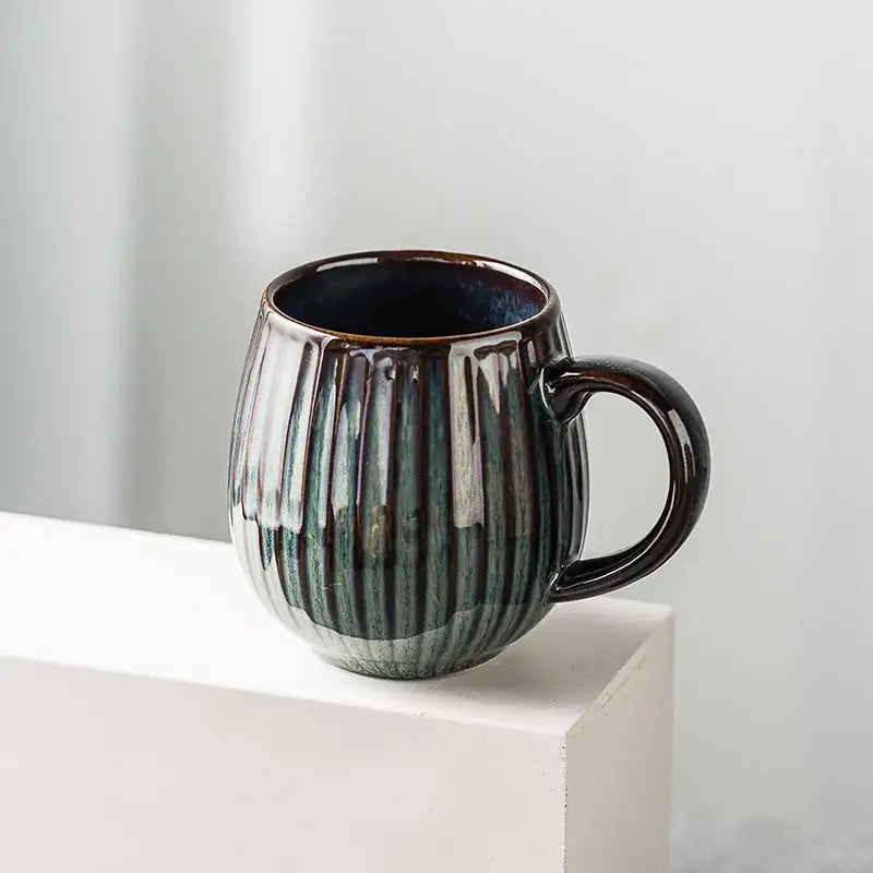Retro japanese ceramic coffee mug with dark green and brown gradient glaze and vertical ribbed texture for kitchen use