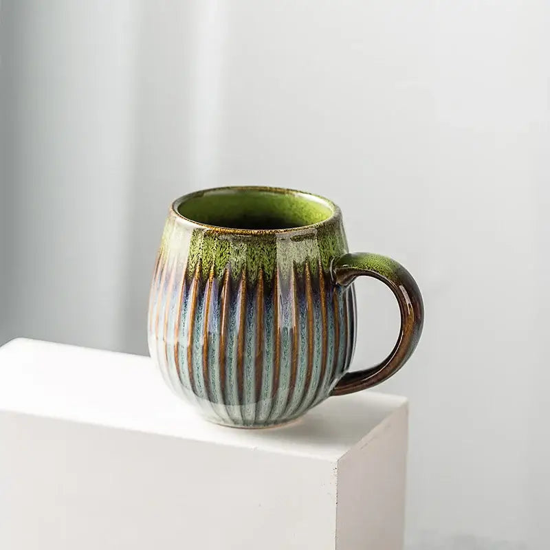 Retro japanese ceramic coffee mug with ribbed body and glossy gradient glaze from olive green to blue and brown stripes