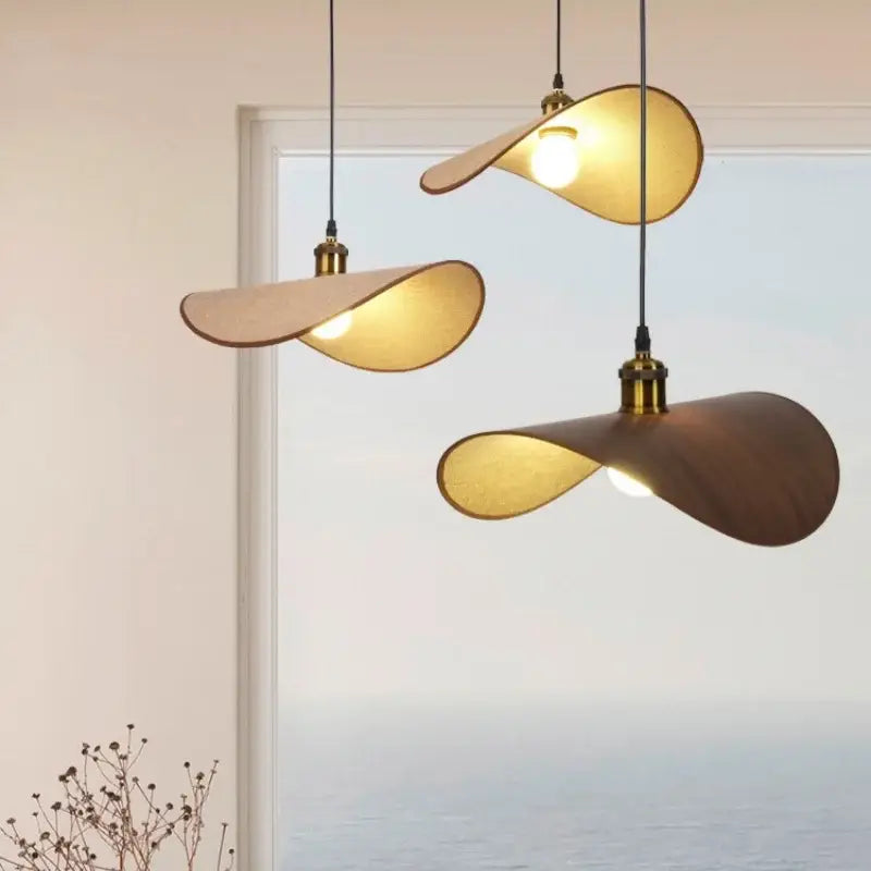 Three modern pendant lights with organic leaf wooden shades in natural and dark wood tones for dining room decorbites hat pendant light