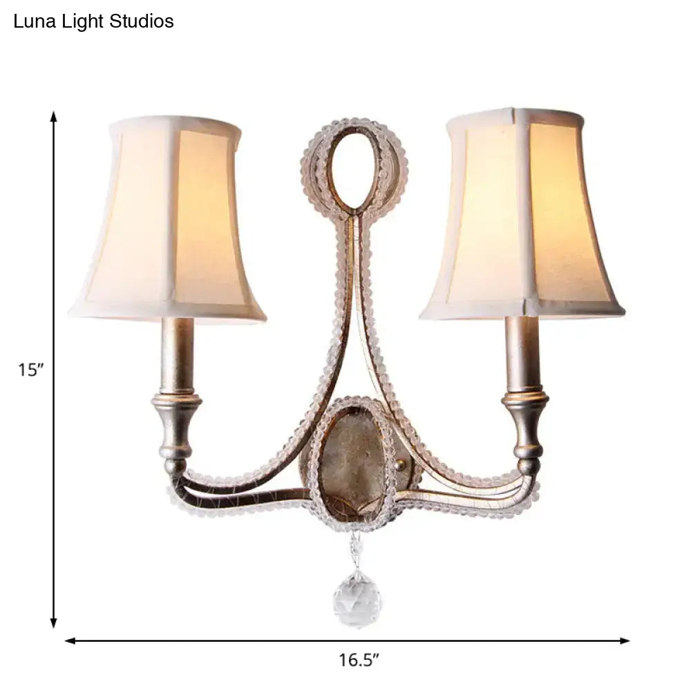 Antique silver two-light wall light with crystal accents and cream retro loft fabric shades for bedroom use