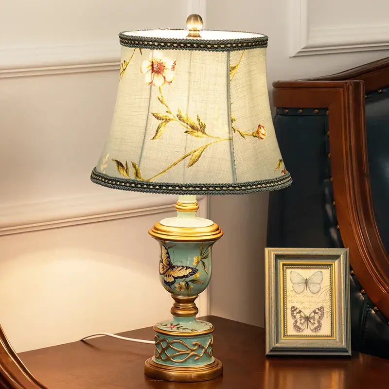 Antique-style table lamp with light blue decorbites green resin base, gold butterfly trim, and embroidered fabric shade