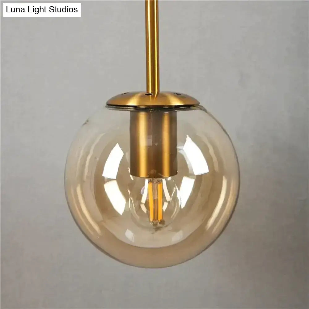 Retro modern glass smoked globe wall lamp with clear glass globe gold hardware and exposed filament bulb for bedroom lighting