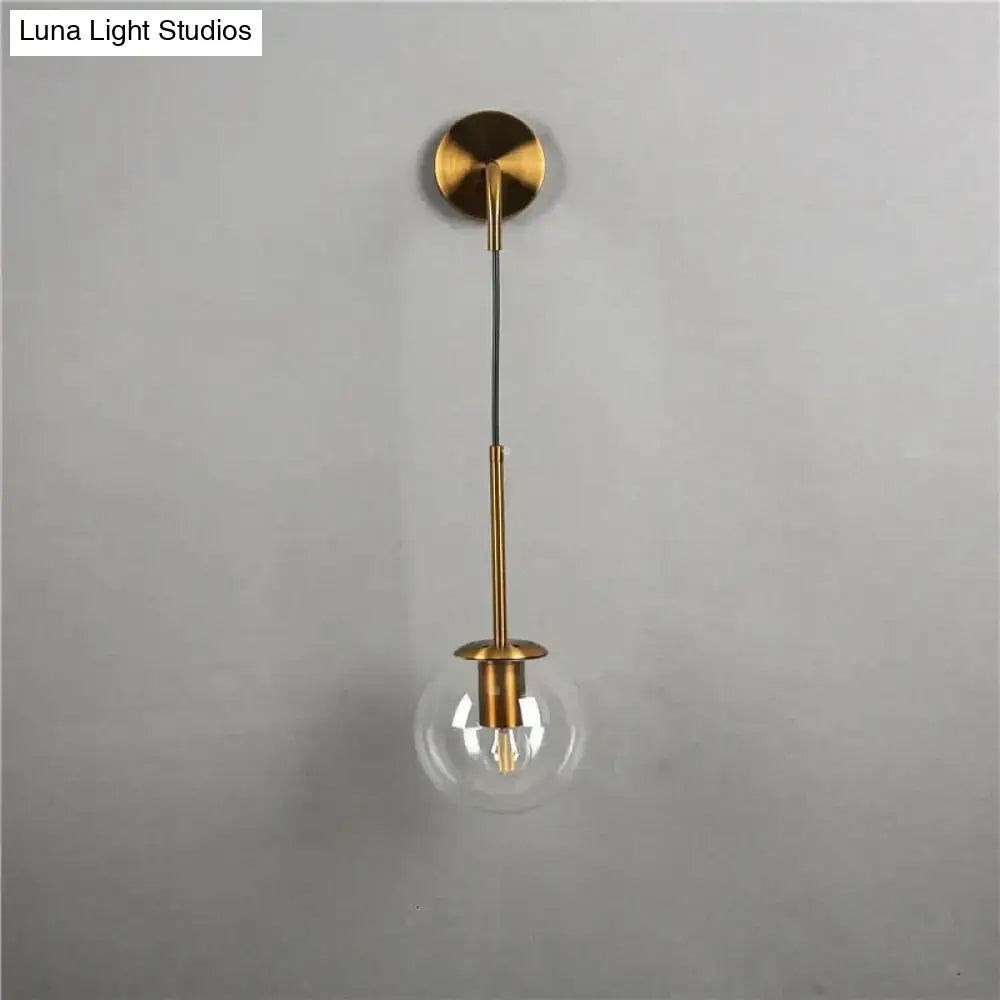 Brass-finished wall lamp with retro modern glass smoked globe and exposed filament bulb for bedroom lighting