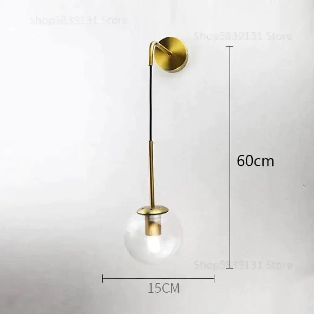 Gold-toned retro modern glass wall lamps with clear globe and slender metallic arm for nordic bedroom lighting