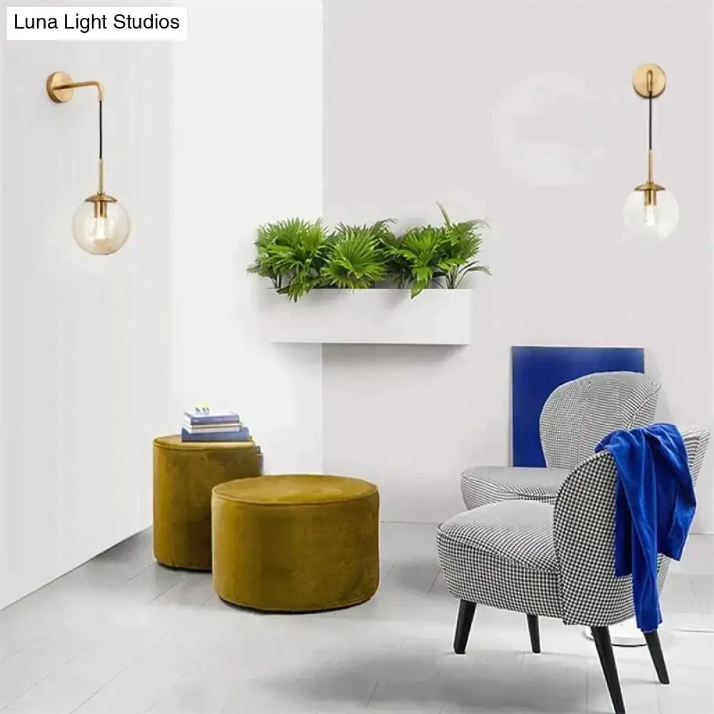 Gold-finished retro modern glass wall lamp with clear globe shade designed for bedroom lighting in nordic style