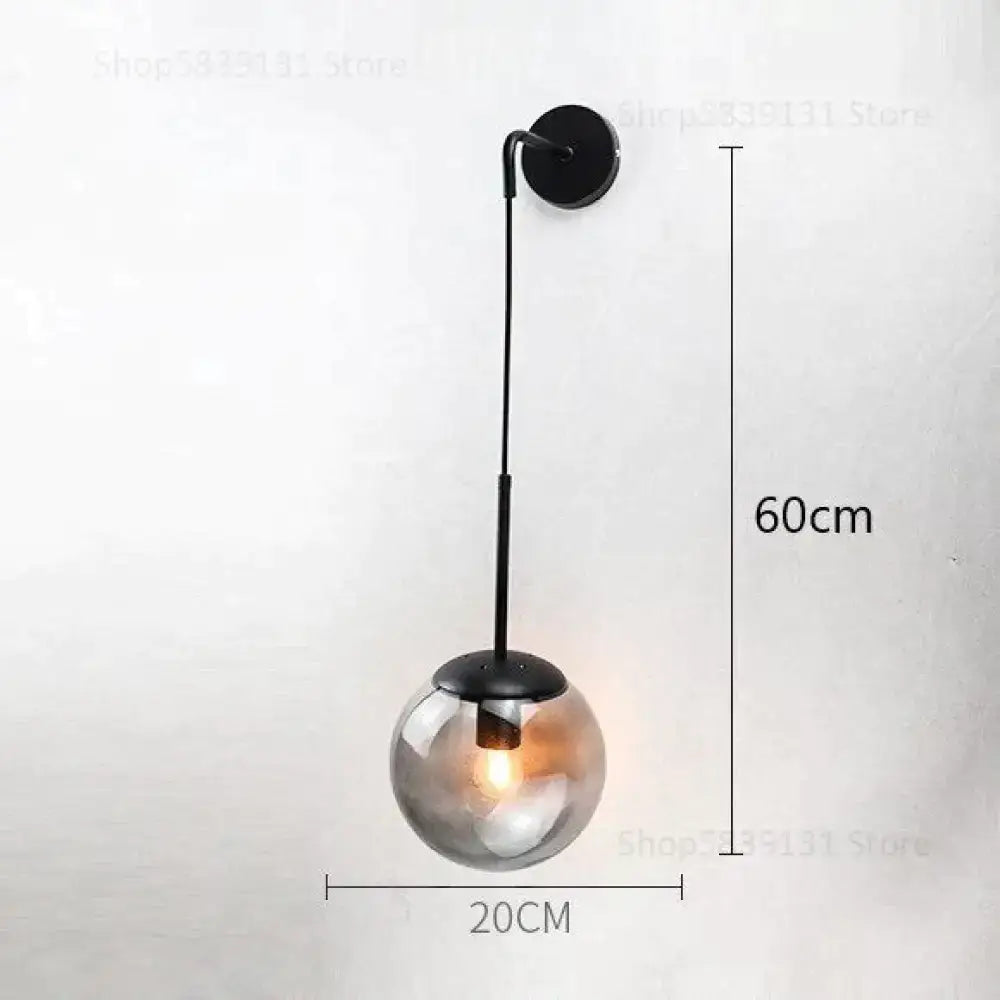 A sleek black metal nordic retro modern wall lamp with a spherical smoked glass globe for bedroom lighting