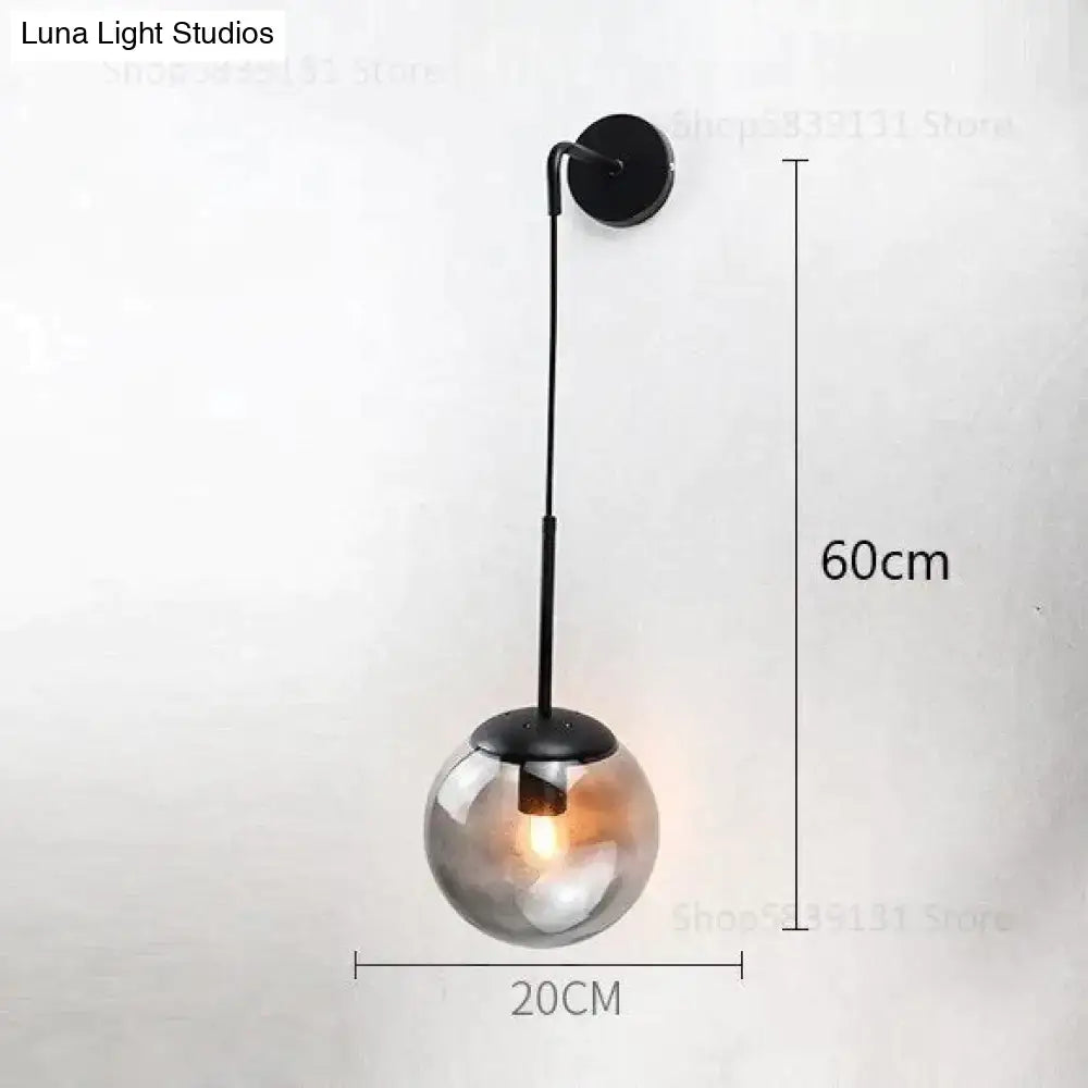 A sleek black metal nordic retro modern wall lamp with a spherical smoked glass globe for bedroom lighting