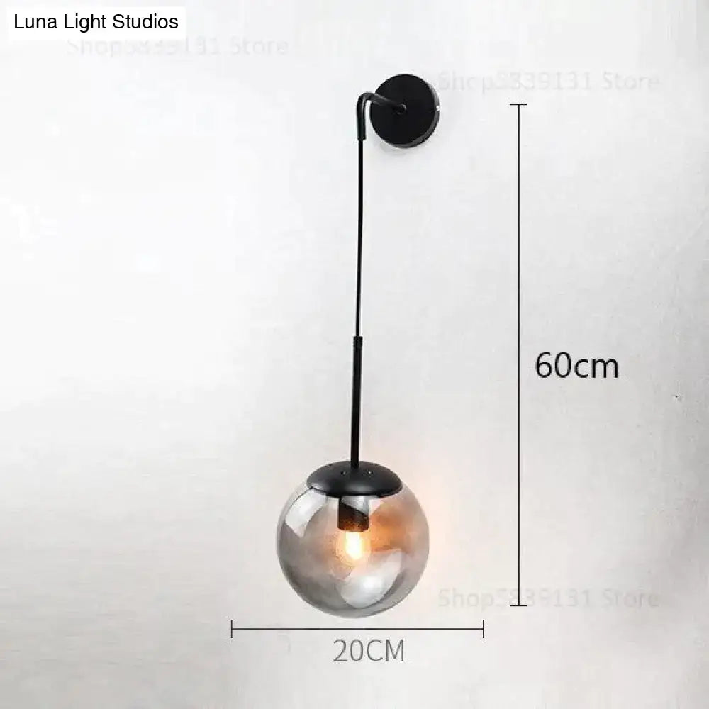 A sleek black metal nordic retro modern wall lamp with a spherical smoked glass globe for bedroom lighting
