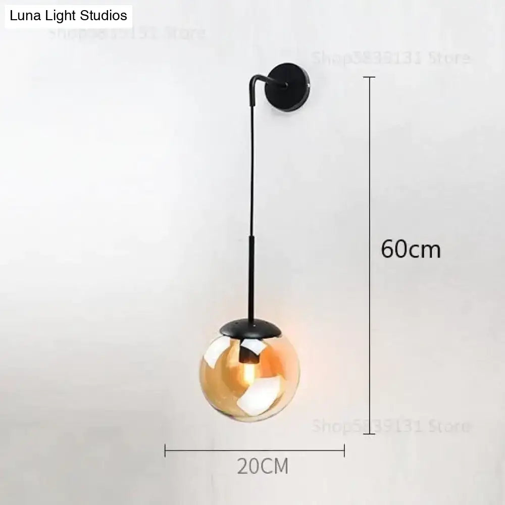 A sleek black metal wall lamp with a hanging amber glass globe retro modern glass for bedroom lighting