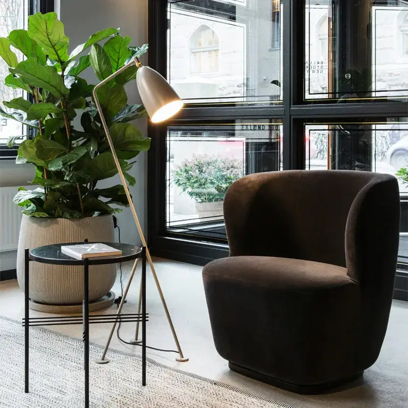 Dark brown velvet armchair with rounded contours next to retro nordic grasshopper floor lamp for stylish living room decorbites grasshopper floor