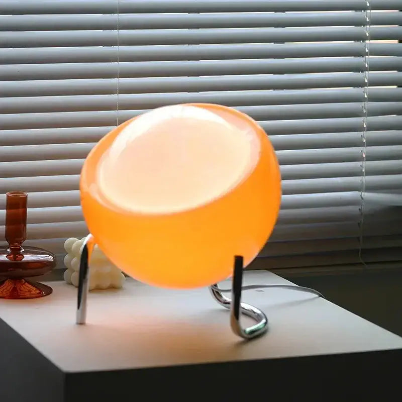 Retro orange glass table lamp with translucent glowing finish on sleek chrome stand for bedroom night light decorbites glass table