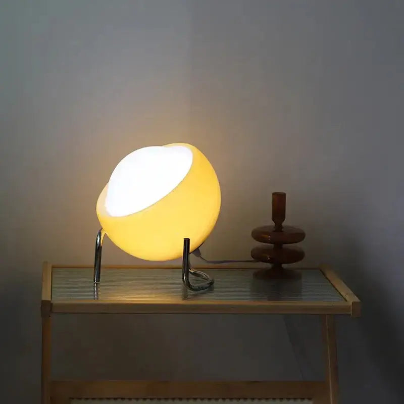 Retro orange glass table lamp with warm yellow glow and minimalist chrome stand for decorbites glass table use