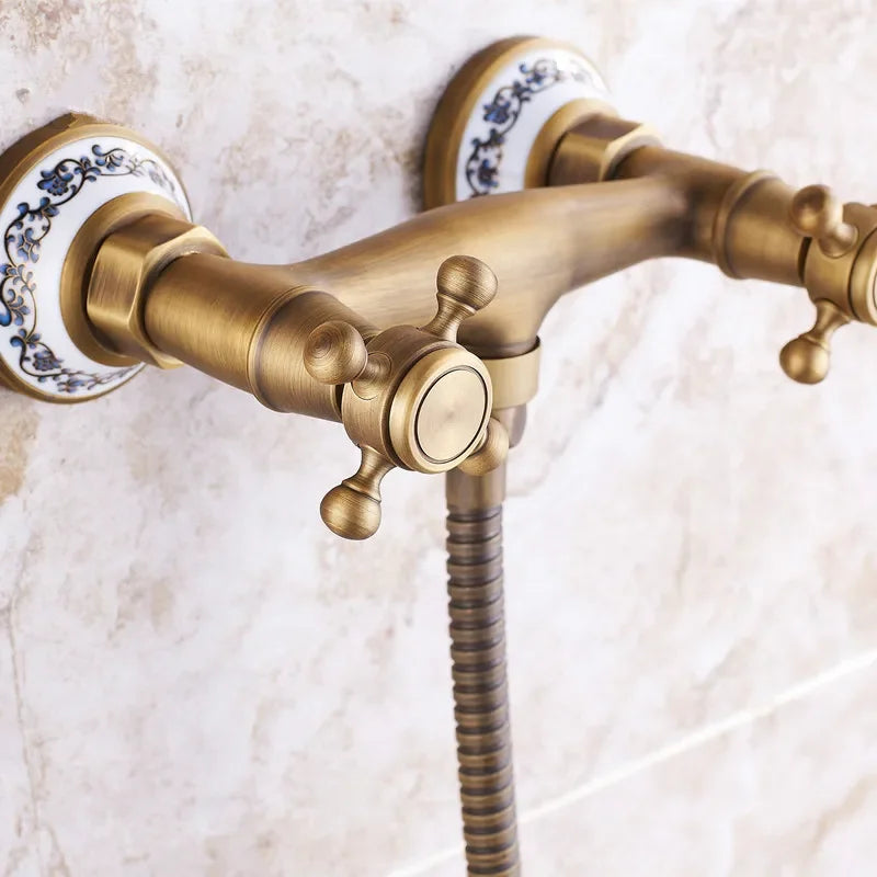 Antique brass double-handle shower faucet with ornate blue and white ceramic escutcheons for wall mount use