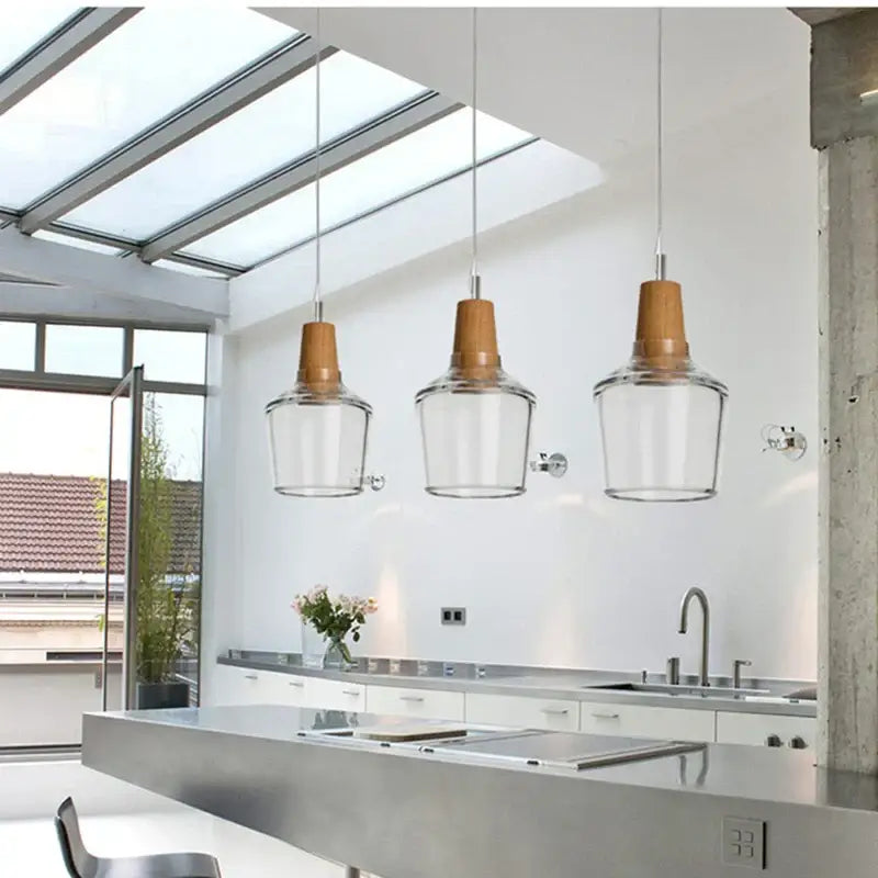Three warm-toned wooden top pendant lights with clear glass lampshades in a retro smoked glass lampshade pendant set