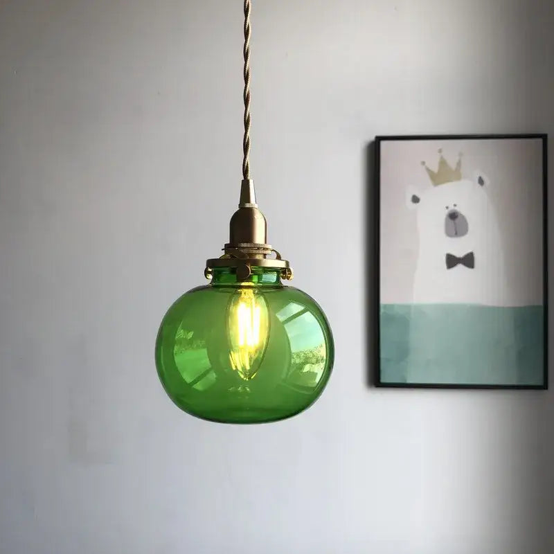Retro teal and brass glass pendant chandelier featuring a round translucent green brass glass pendant with twisted cord