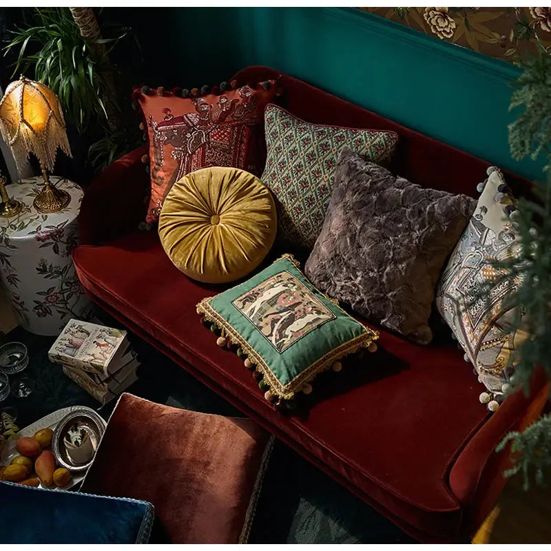 A plush circular gold velvet pillow with tufted center and pom-pom trim for decorbites american luxe retro cushion covers