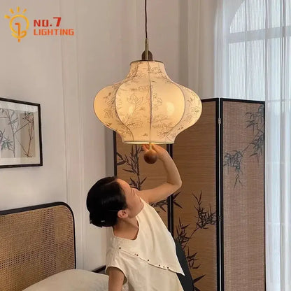 A cream fabric retro pendant light with floral embroidery and brass frame by decorbites wabi-sabi for bedroom decor