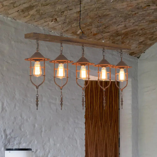 Rustic wooden beam ceiling light with five copper-toned lanterns and iron cage design for dining room lighting fixture