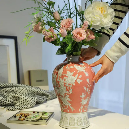 A coral-pink ceramic vase with intricate white porcelain vase patterns on a decorative base for living room decorbites blue white style