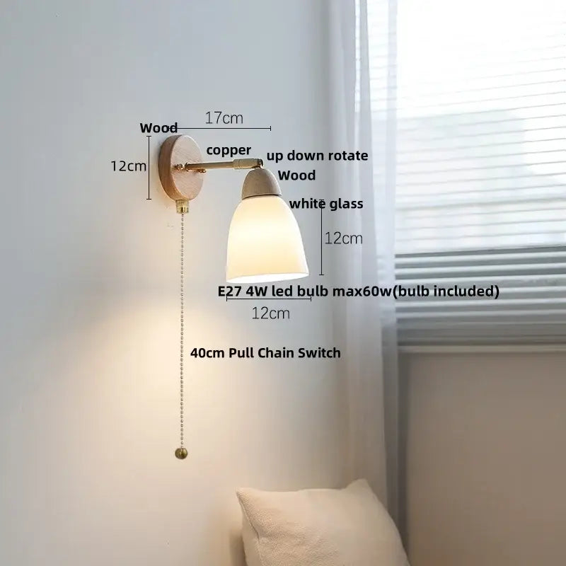 A warm-toned wall sconce light with a wooden base copper arm and white glass shade for bedroom use