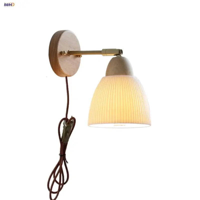 Warm-toned ribbed ceramic wall sconce light with brass arm and wooden backplate for bedroom use