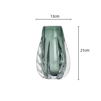 A sleek translucent sage green decorbites crystal vase with leaf-inspired design and clear cut facets for living room decor