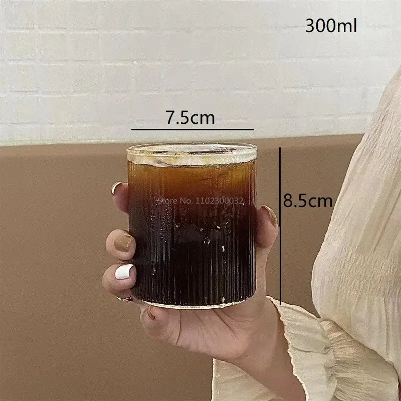 Clear glass coffee tumbler 300ml with ribbed design filled with dark liquid and ice from decorbites glass cups set