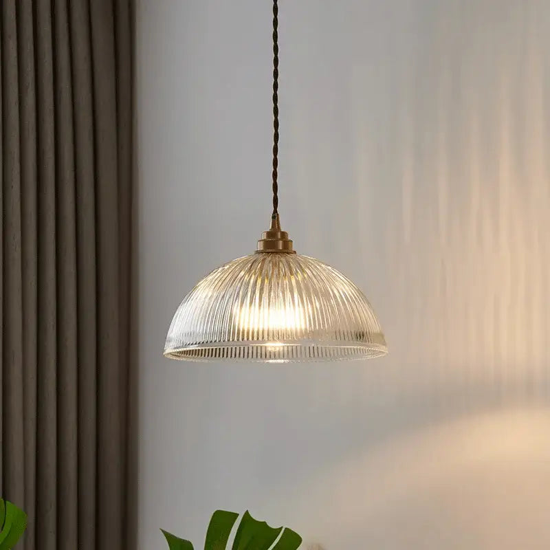 Clear ribbed glass chandelier pendant light with brass finish and twisted dark cord for bedroom pendant lights