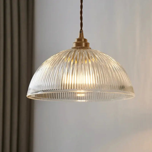 A warm-toned ribbed glass chandelier pendant light with brass finish and twisted cord for bedroom pendant lights