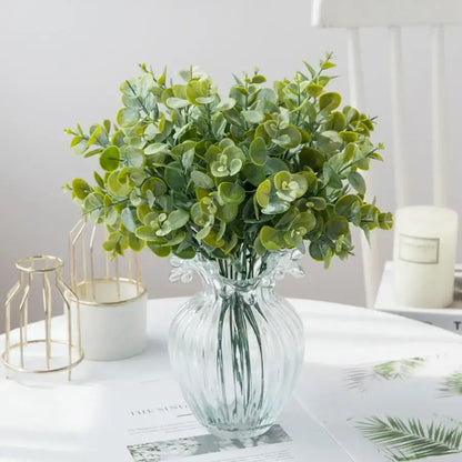 A clear ribbed glass eucalyptus leaves vase with round green artificial eucalyptus leaves for lavender living room decor