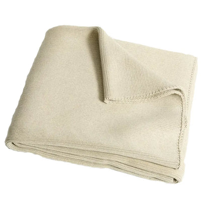 Beige knitted throw blanket with soft textured weave and stitched edges paired with ribbed gray organic cotton weighted blanket