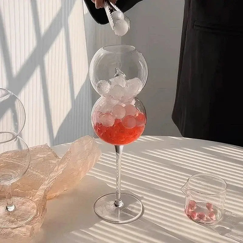 A clear double-globed glass mug with ribbed heart love design filled with ice and red liquid from decorbites glass mugs