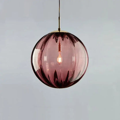 A spherical amethyst glass globe pendant light with brass fixture and exposed bulb for dining room iron finish