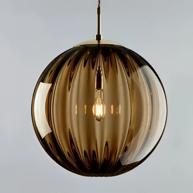 Spherical amber glass globe pendant light with vertical ribbed texture and visible filament bulb iron finish for dining room