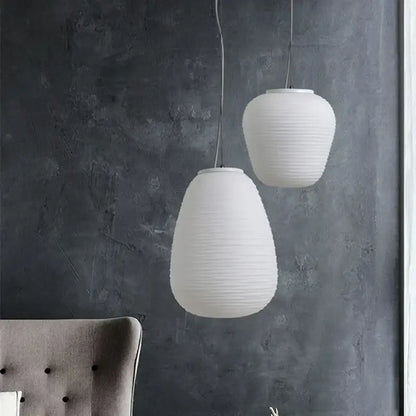 Two off-white ribbed paper pendant lights hang against a dark wall decorbites glass cocoon pendant light kitchen lamp