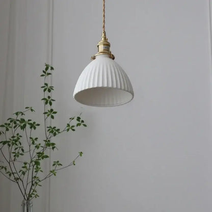 White ribbed ceramic pendant light fixture with brass knob switch and twisted copper cord for kitchen lighting