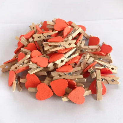 A pile of romantic heart shape wood clips with vibrant orange painted tops and natural wood bodies for bedroom decor