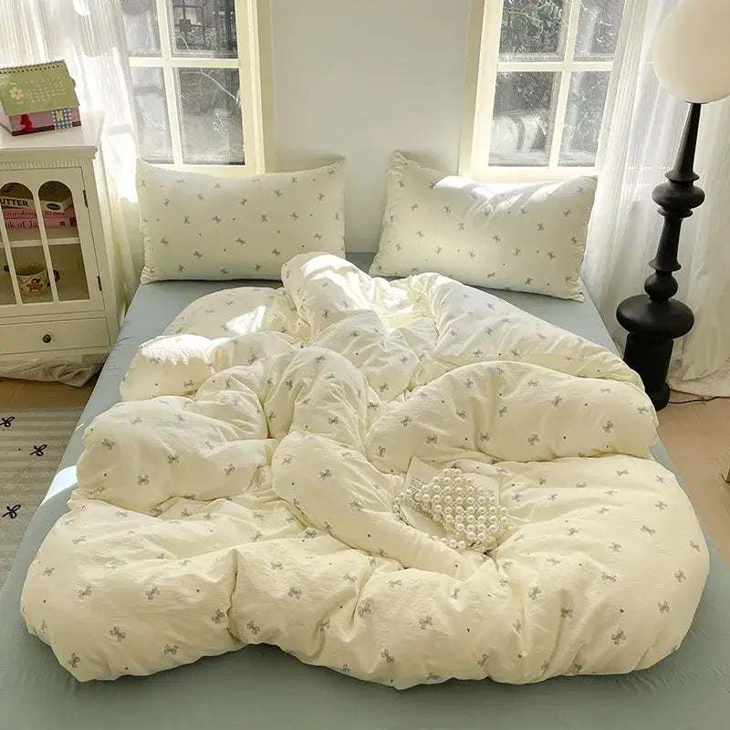 Romantic pink cotton flower print bedding set featuring a cream-colored quilt with delicate gray bows decorbites cotton flower