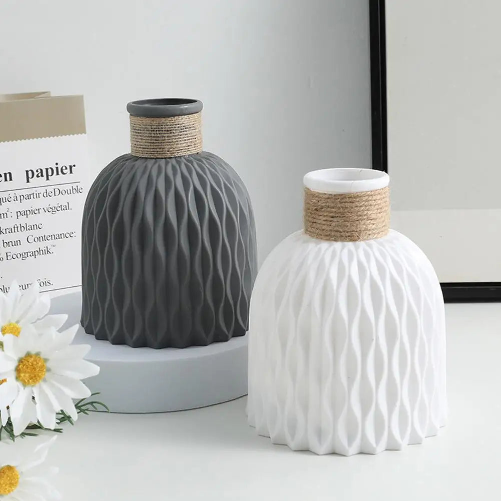 Two ceramic rope plastic vases in matte gray and white with wavy texture and jute-wrapped neck for home decoration