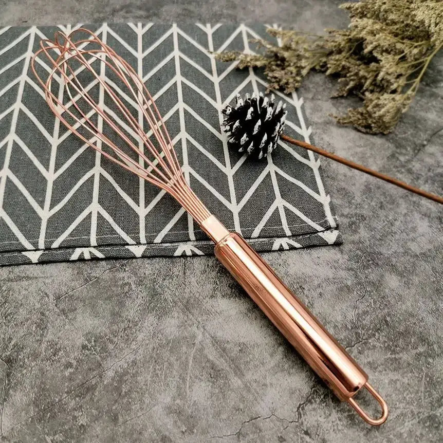 Rose gold metal egg beater whisk with polished handle and fine wire loops from decorbites gold steel kitchen set