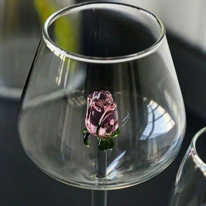 A delicate pink glass decorbites 3d rose with green leaves inside a clear rose stemware wine glass for dining room decor
