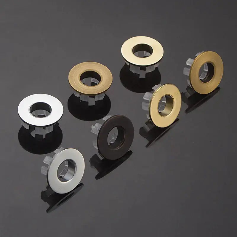 Set of six circular metal brass sink overflow cover inserts in brushed silver polished gold and matte black finishes by decorbites