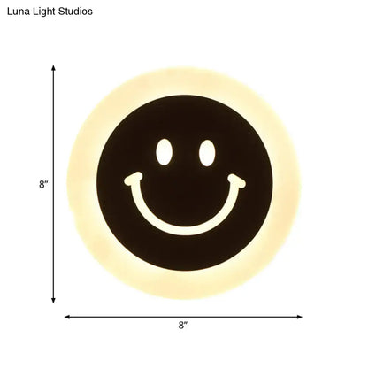 Round led smiley wall sconce with circular black face and warm white light cream halo for bedroom decor
