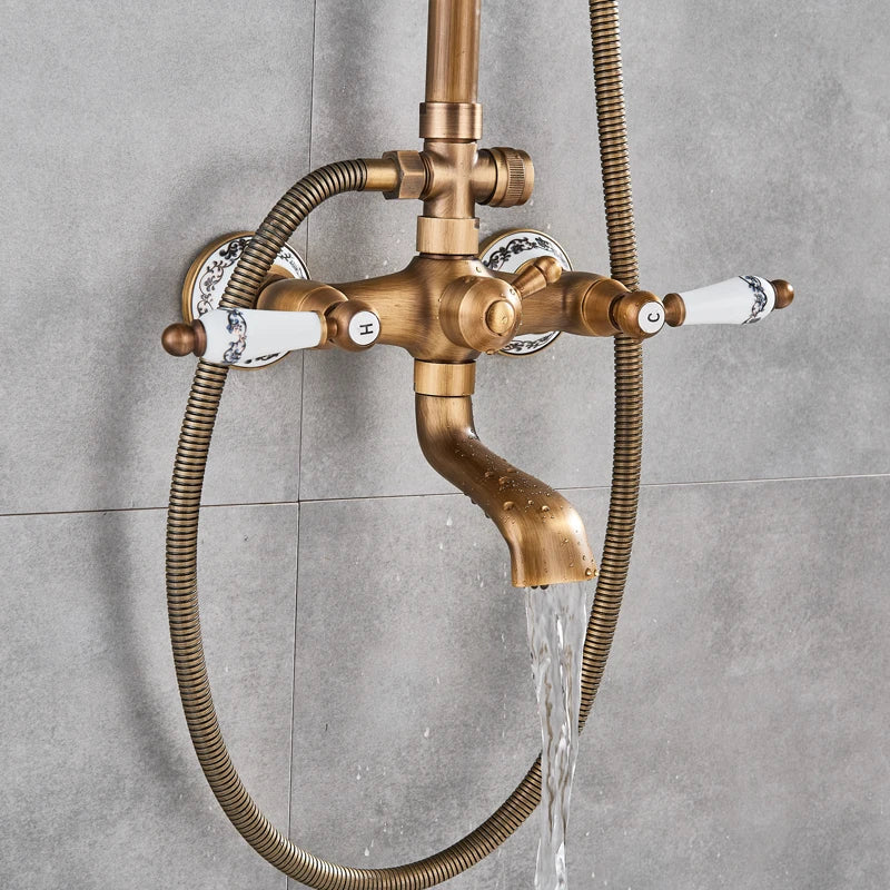 Antique brass shower faucet with white ceramic handles featuring blue floral patterns and a flexible hose for bathroom use