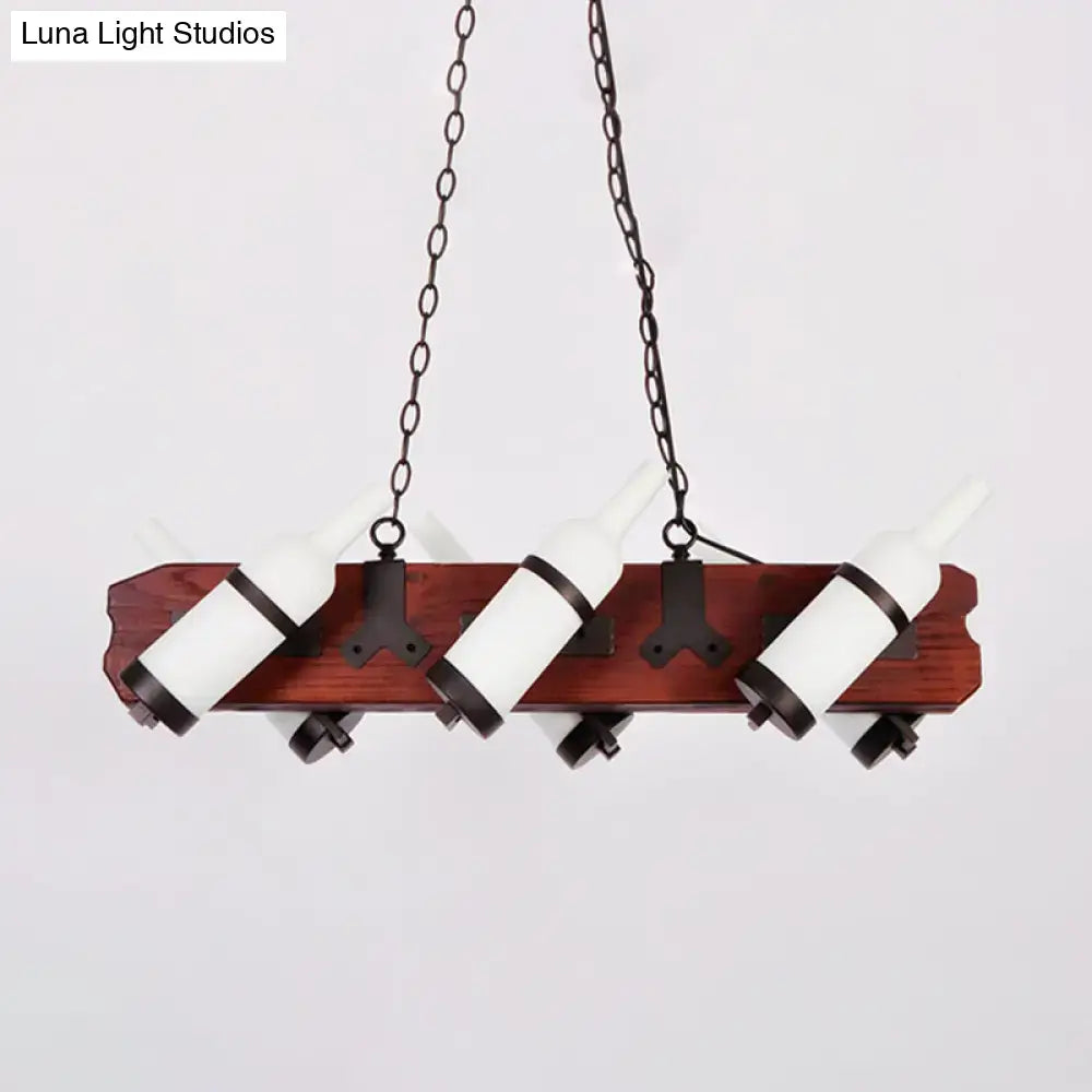 A rustic island lamp with frosted white glass bottles suspended by black metal bands on a brown wood arm plank