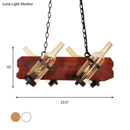 Rustic island lamp with brown wood arm and frosted white two amber glass wine bottles suspended by dark chains