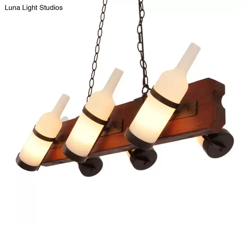 Warmly glowing island lamp with frosted white glass bottles and brown wood arm suspended by black metal chains