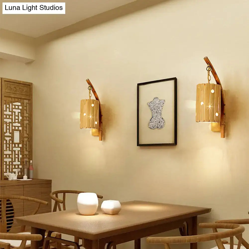 Pair of rustic bamboo cylinder house sconce light fixtures with warm glowing light and decorative cutouts for bedroom walls
