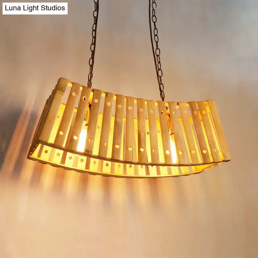 Golden curved bamboo linear island pendant light with vertical slats and circular cutouts for dining table lighting